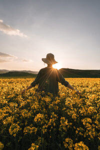 femme-reflechie-marchant-parmi-fleurs-campagne-notion-melancolie